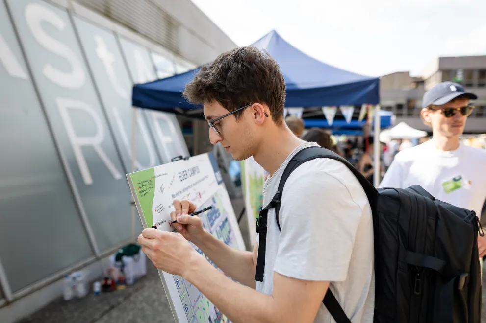 Studierende vor dem Campusplan nimmt teil an einem Partizipationsformat. zu Außenflächen.