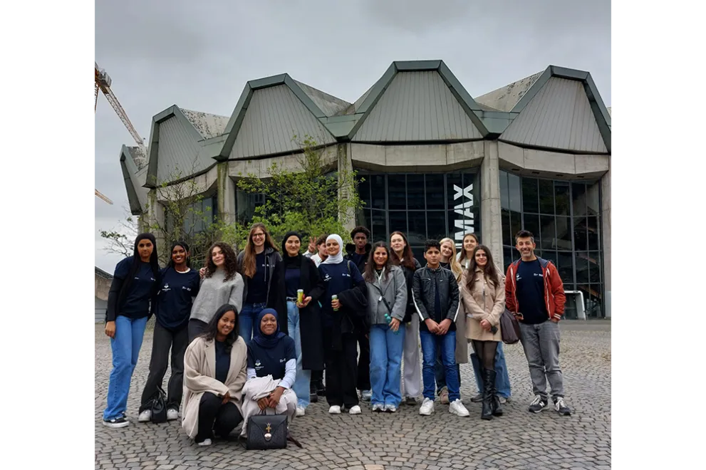 Foto: Gruppenfoto der Schülerinnen und Schüler der Herbstferienakademie 2025 vor dem Audimax an der Ruhr-Universität Bochum. Es ist bewölkt.