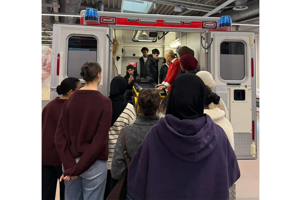 Foto: Gruppe der Herbstferienakademie vor und in einem Rettungswagen in der DASA.