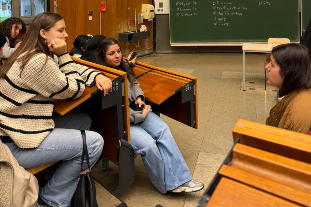 Im Hörsaal sprechen Teilnehmerinnen des Ferienakademie mit einer Mitarbeiterin der Zentralen Studienberatung