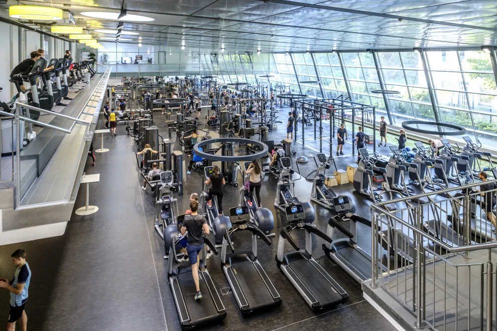 Viele Menschen treiben Sport in einem großen Fitnessstudio