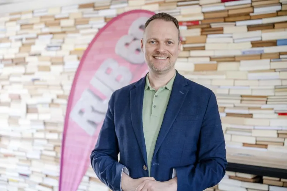 Kai Gehring steht vor einer Bücherwand