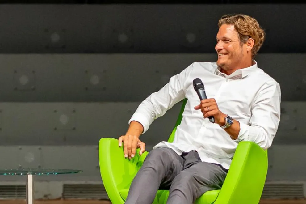 Edin Terzic sitzt auf einem Stuhl und hält ein Mikrofon in der Hand