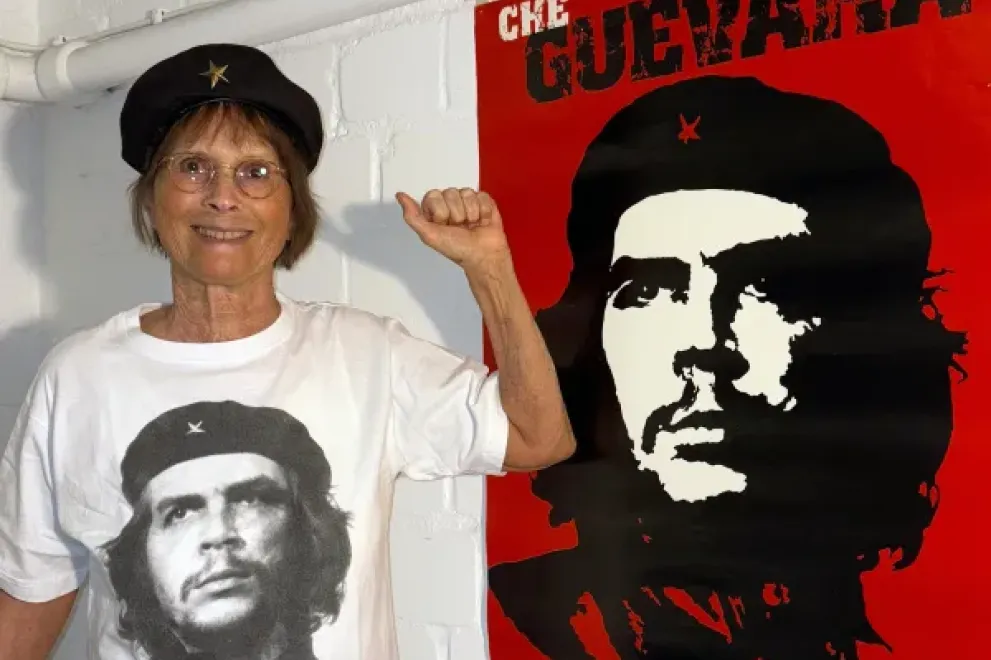 Eine Frau steht mit einem T-Shirt mit Che Guevara-Motiv vor einem Plakat von Che Guevara