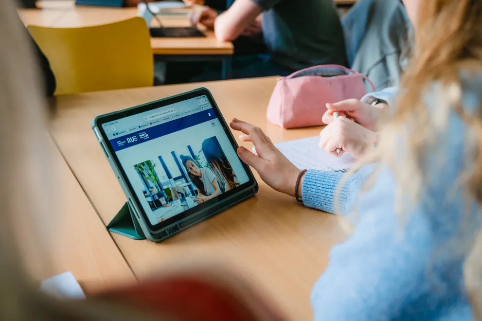 Studentin mit Tablet, auf der die Ersti Pilots Website geöffnet ist