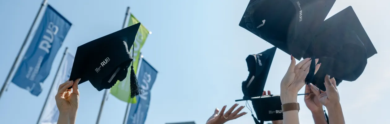Alumni-Management_hero Eine Gruppe Menschen wirft ihre Doktorhüte in die Luft
